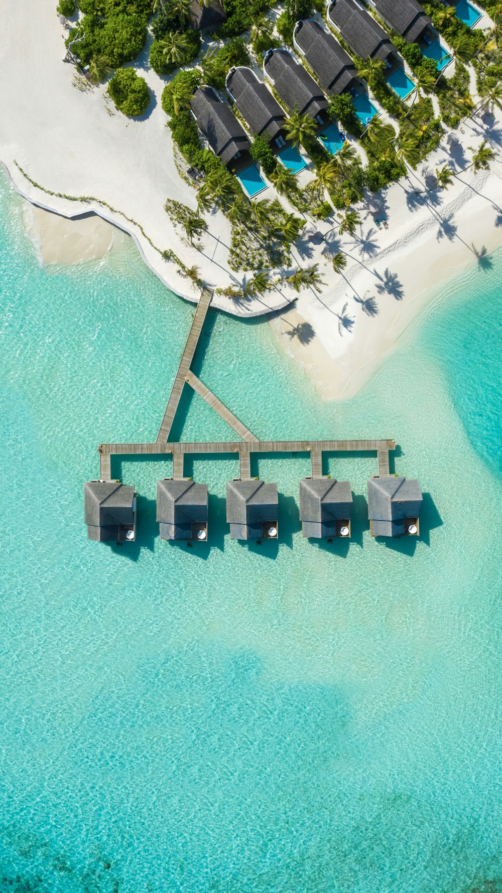 brown huts on body of water in aerial photography