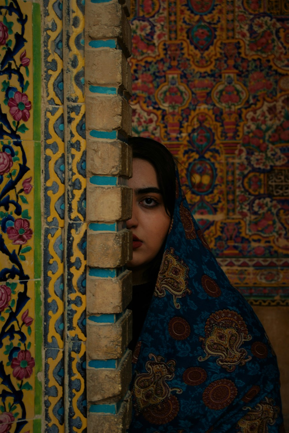 woman half hiding on concrete post