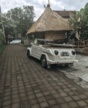 A sleek rental car parked near Divine Villa with tropical plants around.