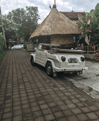A rental car parked near a colorful house, ready for a day of island exploration.