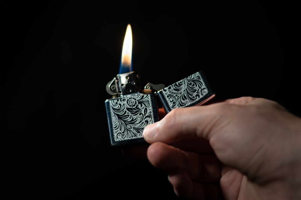 person holding silver and black flip lighter