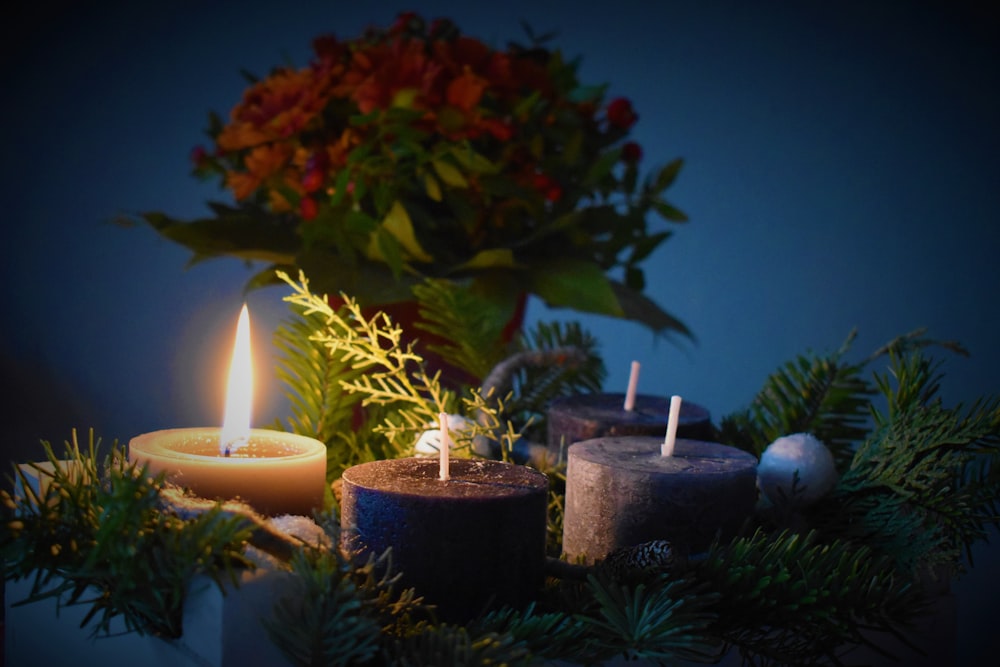 lighted candle beside another 3 candles