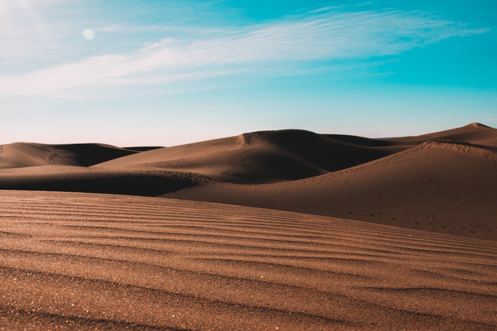 brown deserted place under blue skies