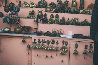 A set of elegant metal handicraft figurines displayed on a wooden shelf.