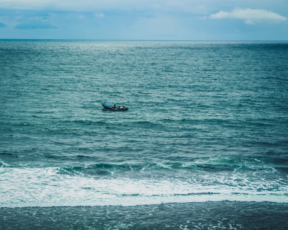 boat on sea under white sky