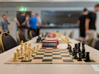 black and white chess board near people standing inside building