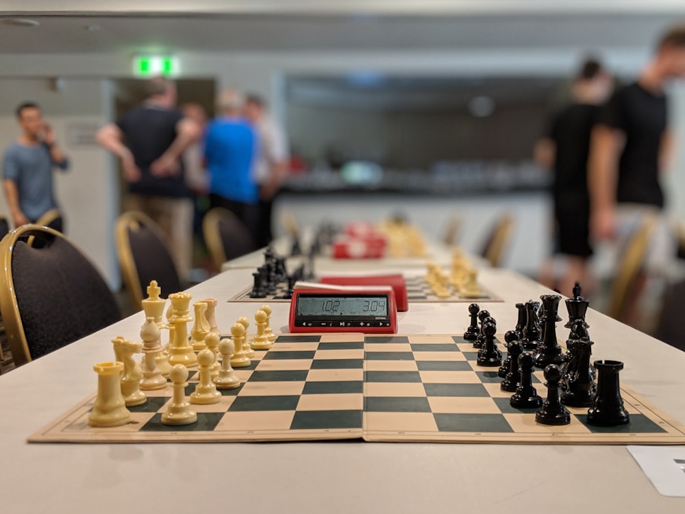 black and white chess board near people standing inside building