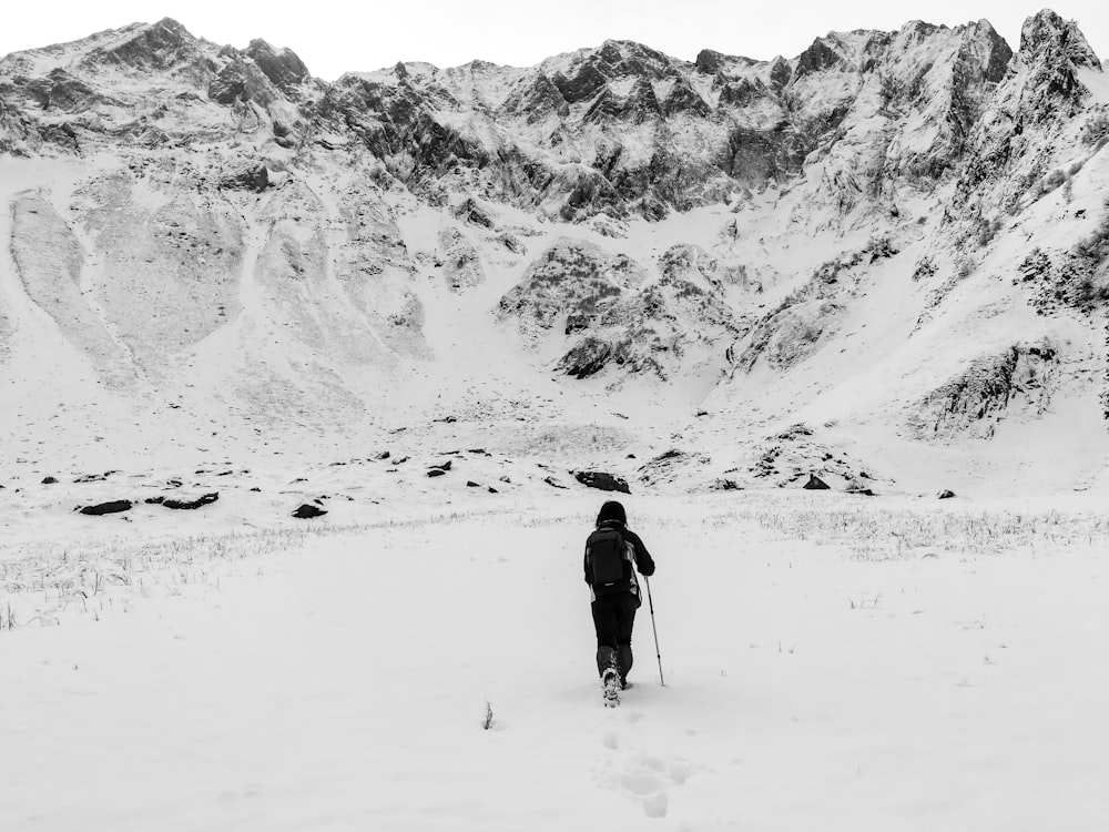 person walking towards snow-covered moutains
