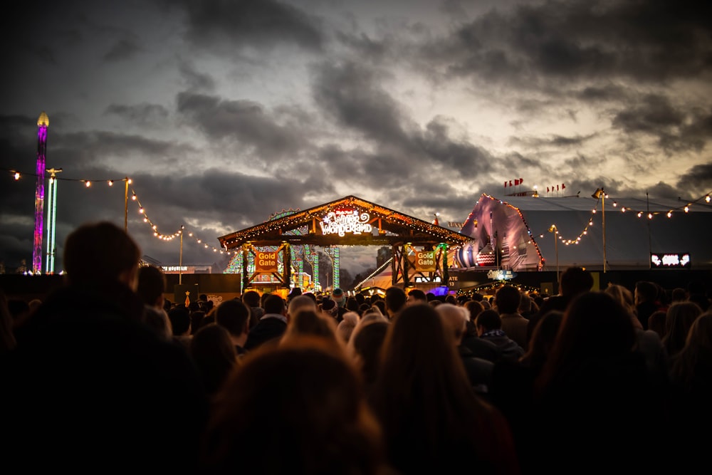 people standing beside brown stage during night time