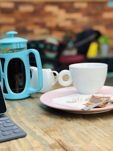 An inviting shot of a single-serve coffee pack next to a small French press.