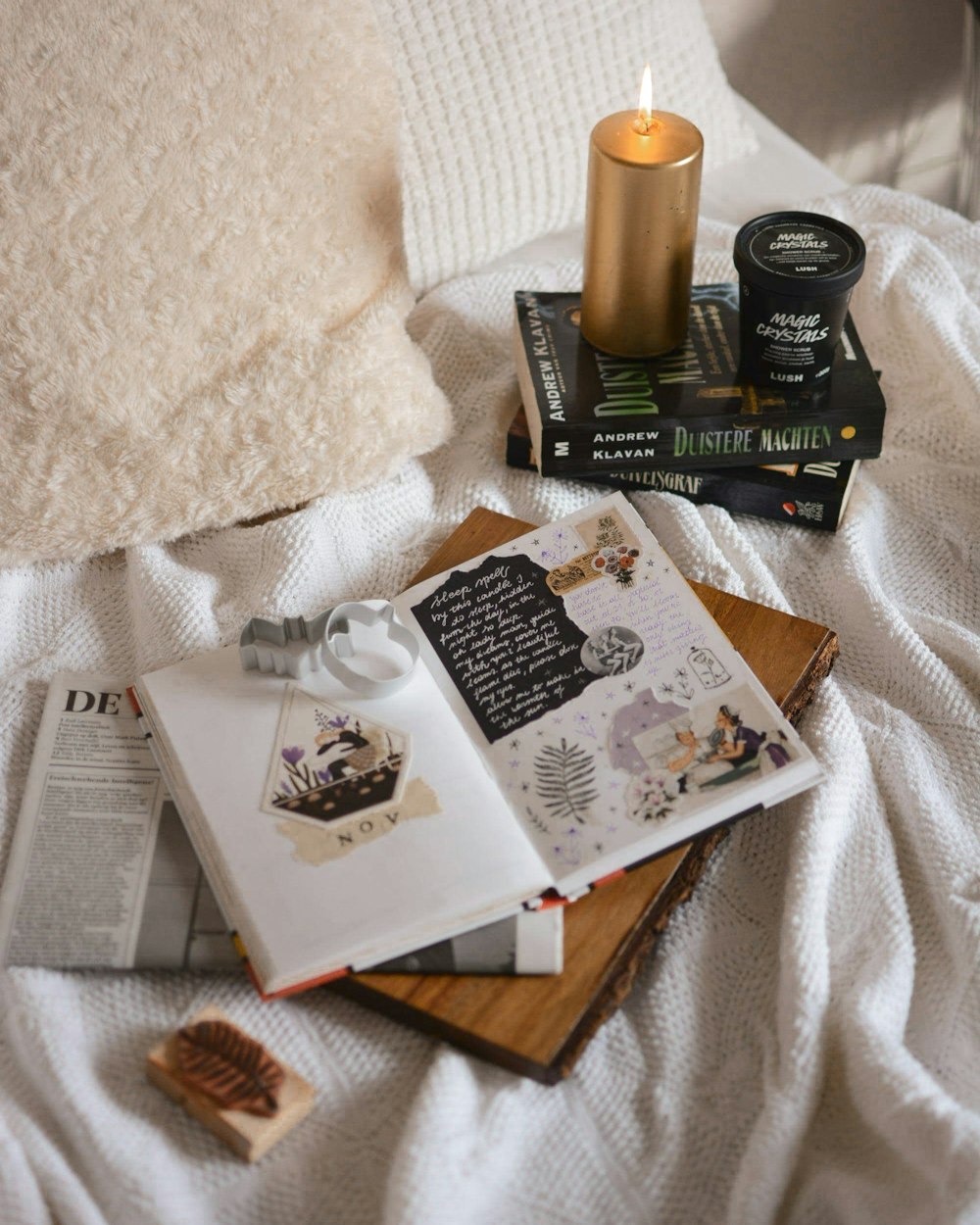 gold pillar candle lighted up on top of black book