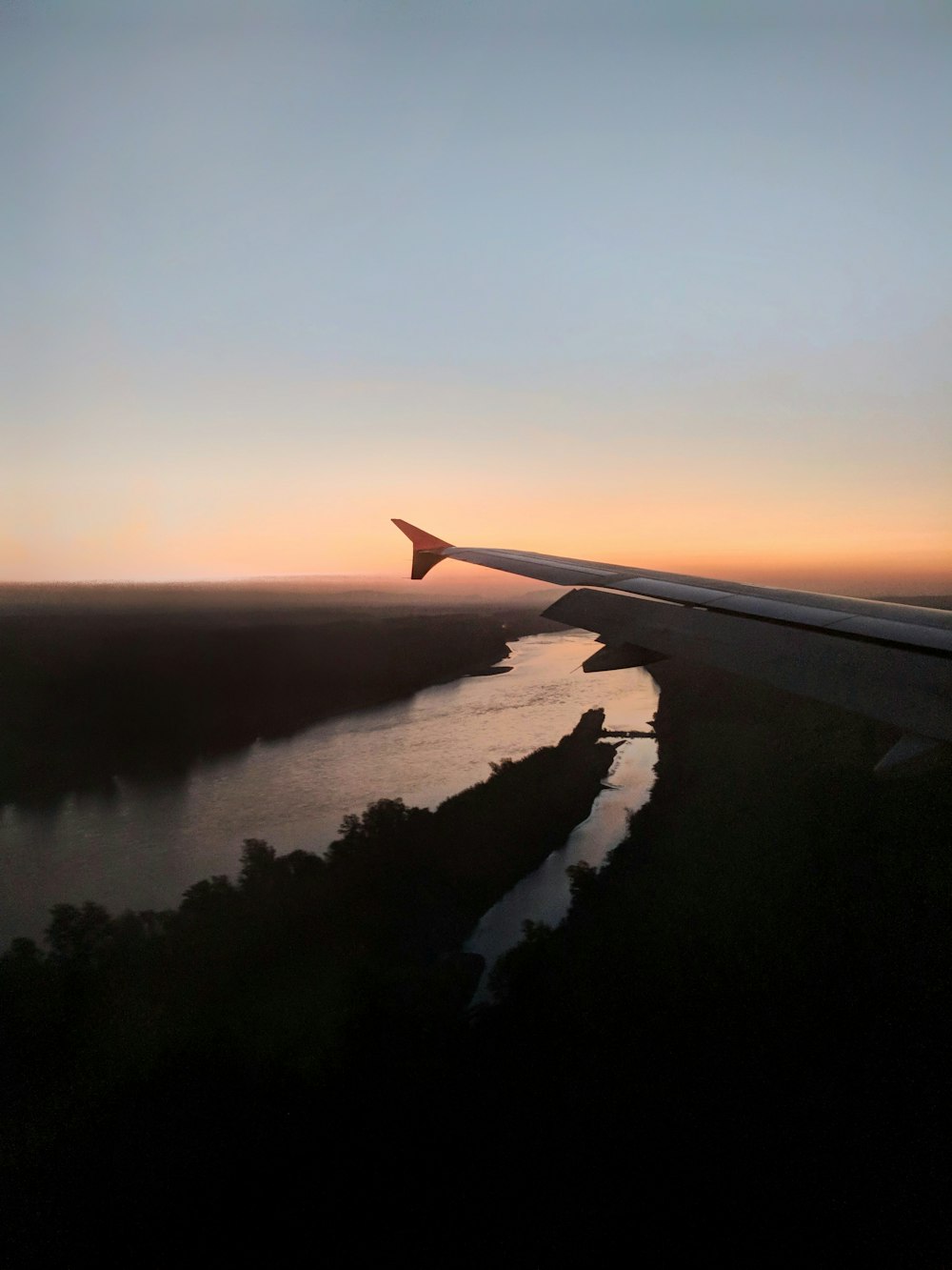 aircraft wingtip overlooking river at night time