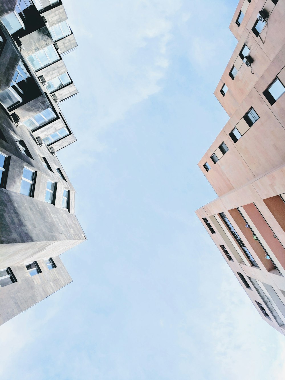 low angle photography of highrise building under cumulus clouds