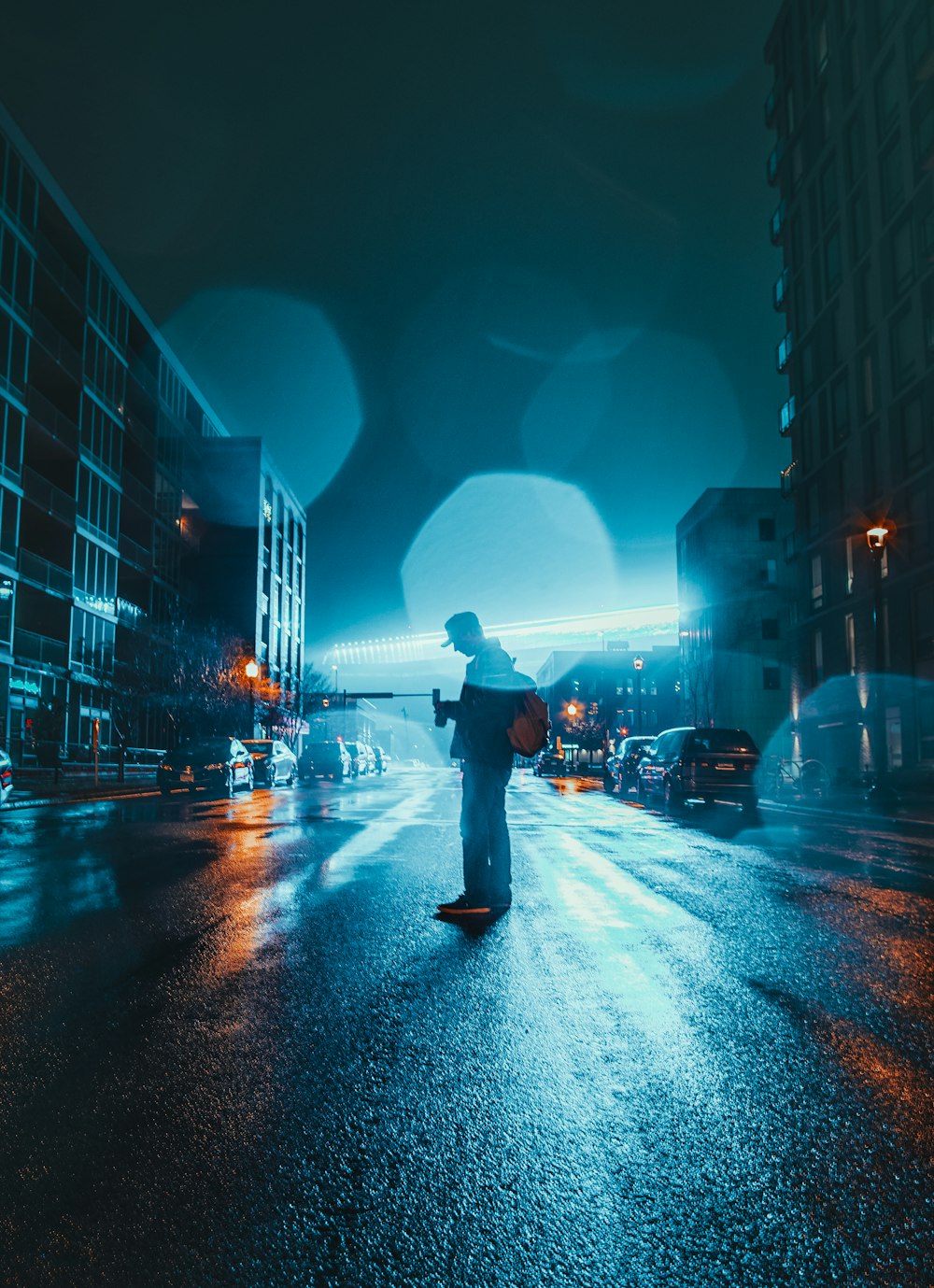 person standing in the middle of road during nighttime