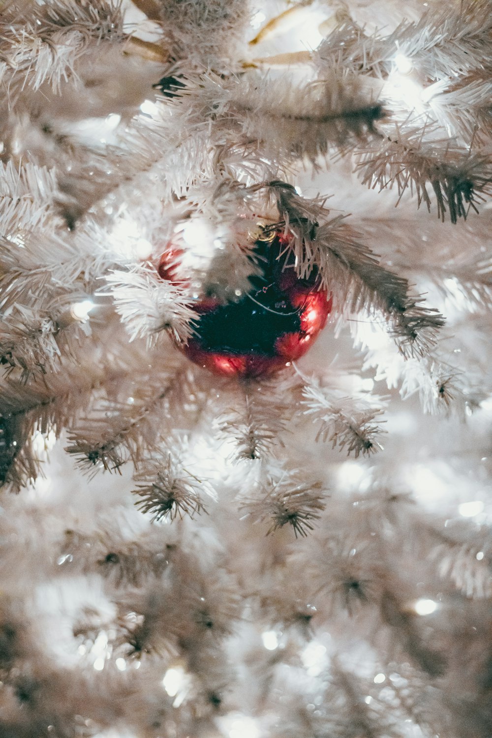 red bauble on white Christmas tree