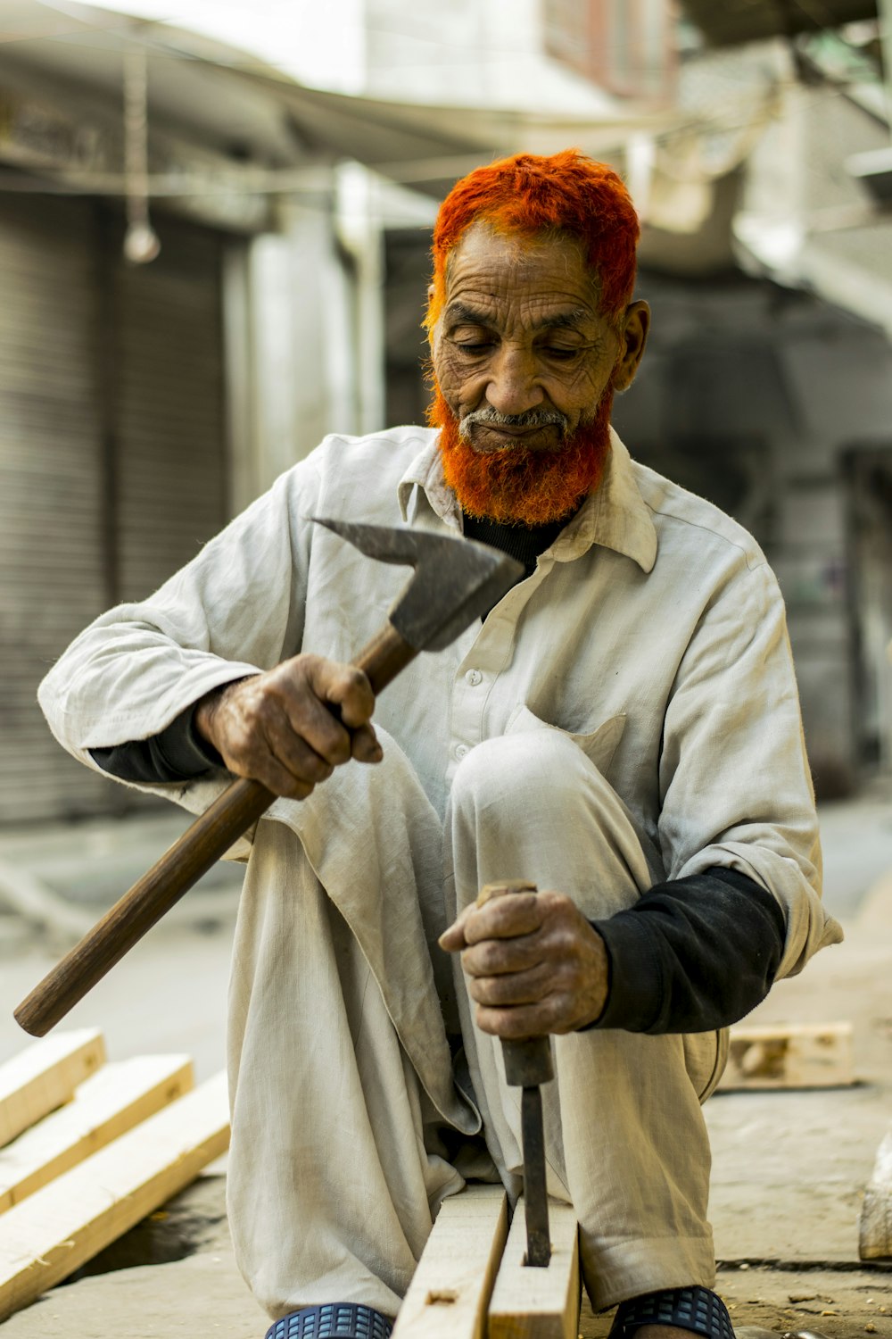 man sitting holding chisel on selective focus photography