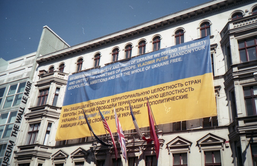 blue and yellow banner placed on white building