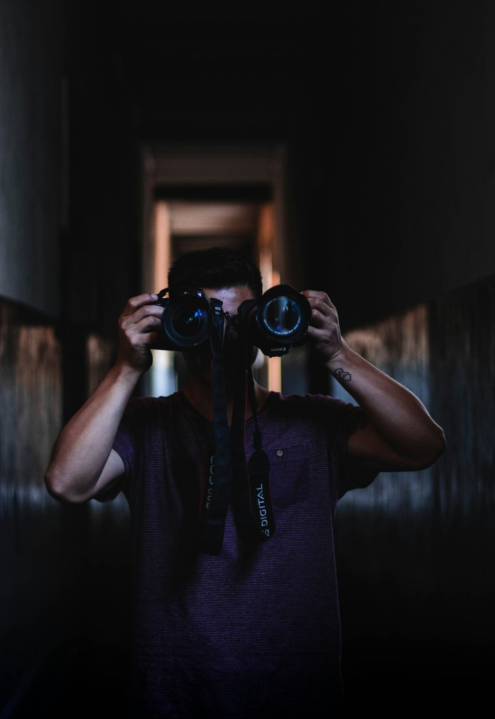 man holding two DSLR cameras on focus photography