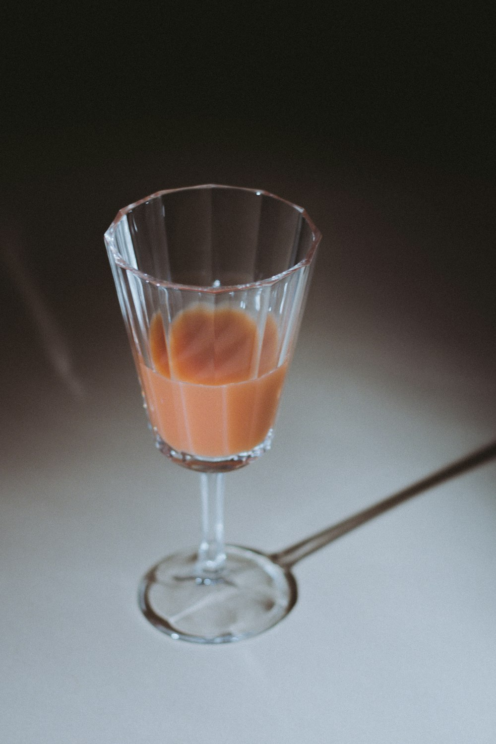 clear footed drinking glass with brown liquid