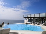Guests relaxing by the infinity pool with ocean views