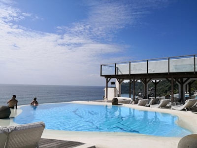 Guests enjoying a refreshing swim in a sparkling infinity pool with ocean backdrop.