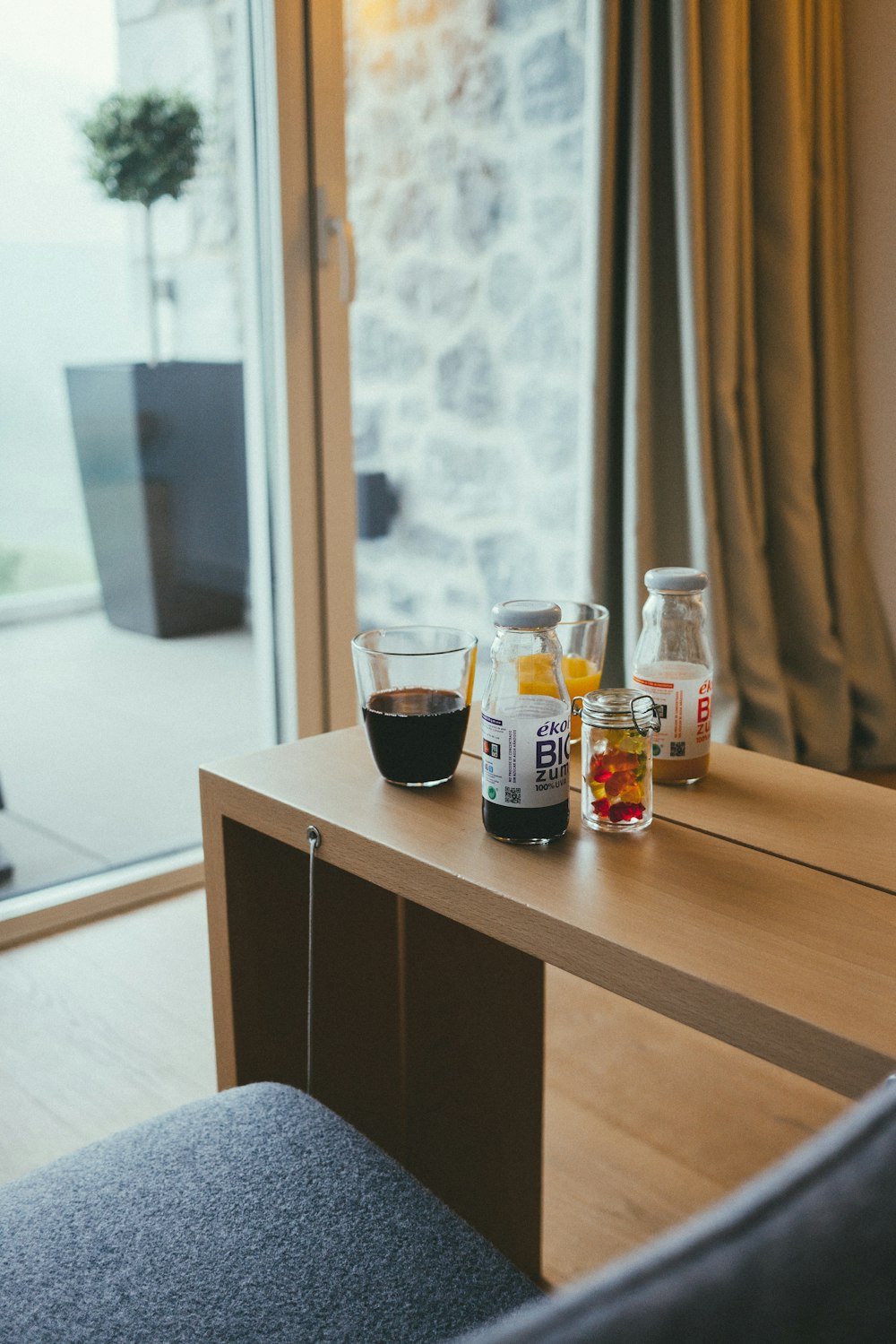 clear glass bottles beside drinking glasses on table