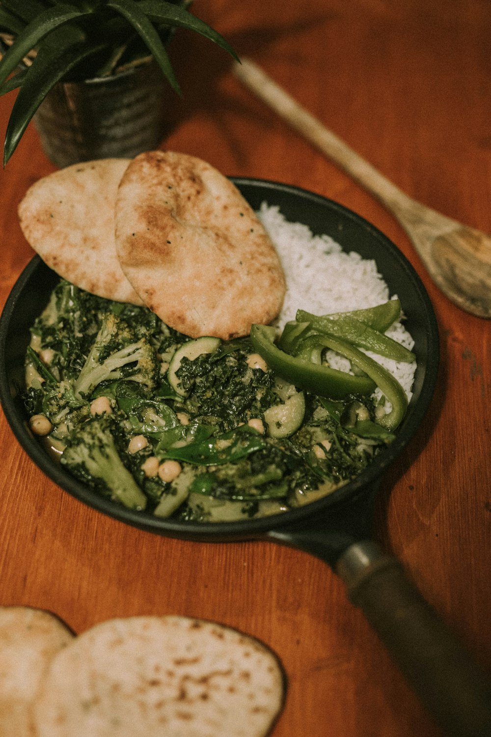 green vegetables and cooked rice in black frying pan