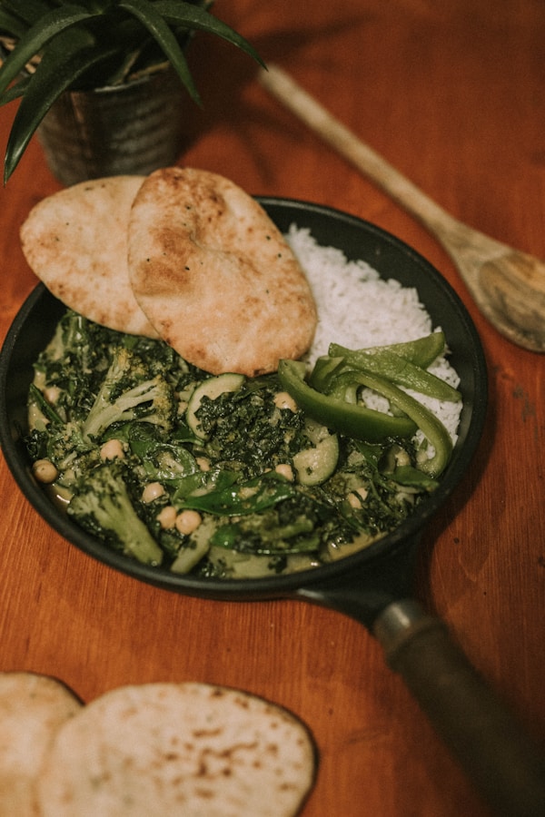 Green vegetables and cooked rice in black frying pan