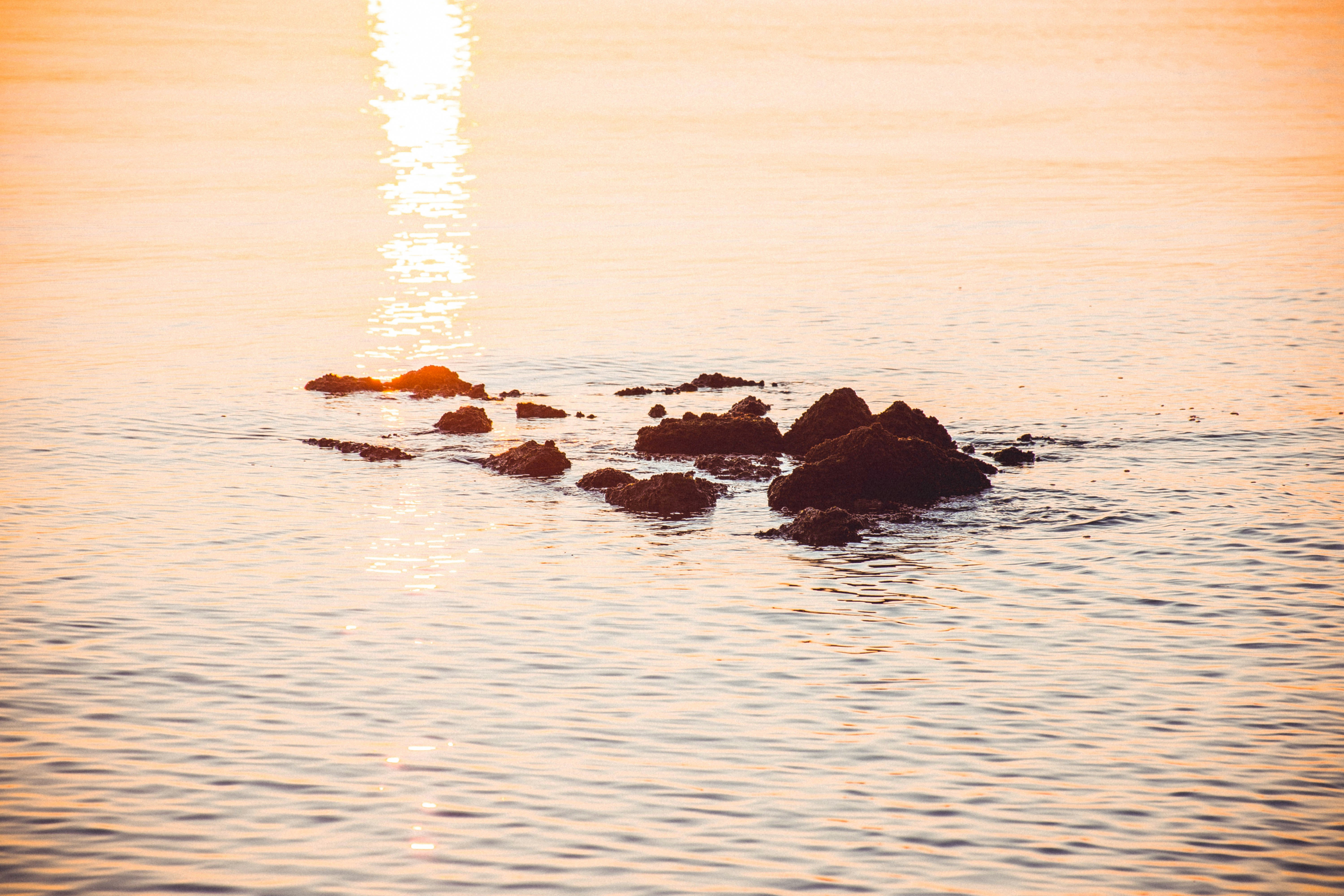 photography of rock monoliths on body of water