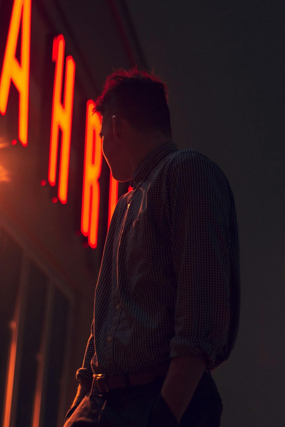 man putting left hand in his pocket at night