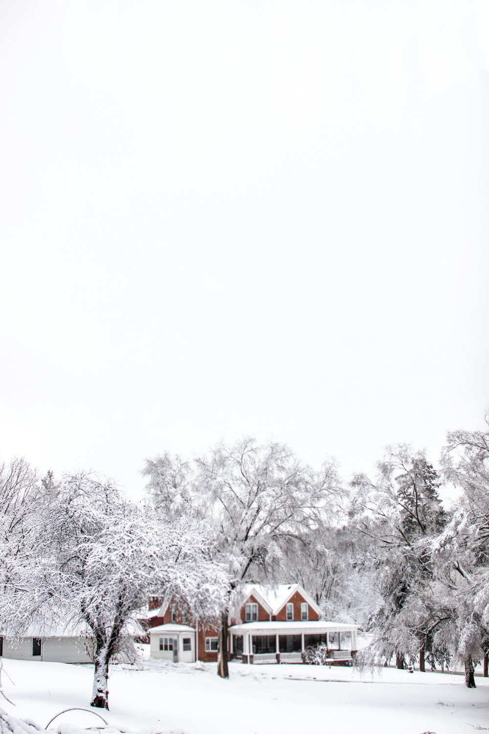 a snow covered field with a house in the background