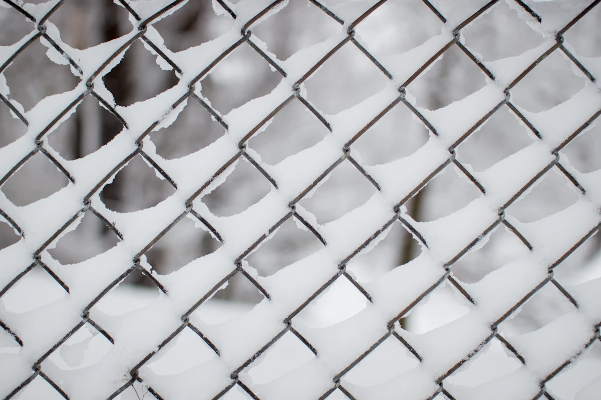 A close up of a fence with snow on it