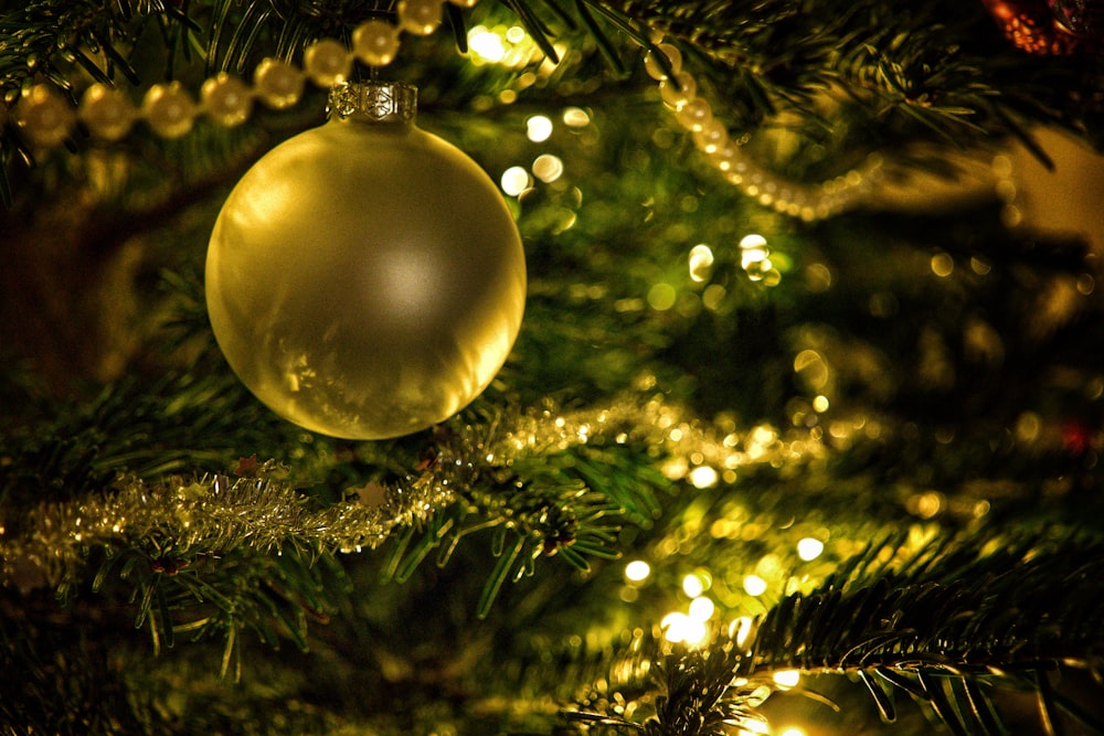 gold bauble on green christmas tree