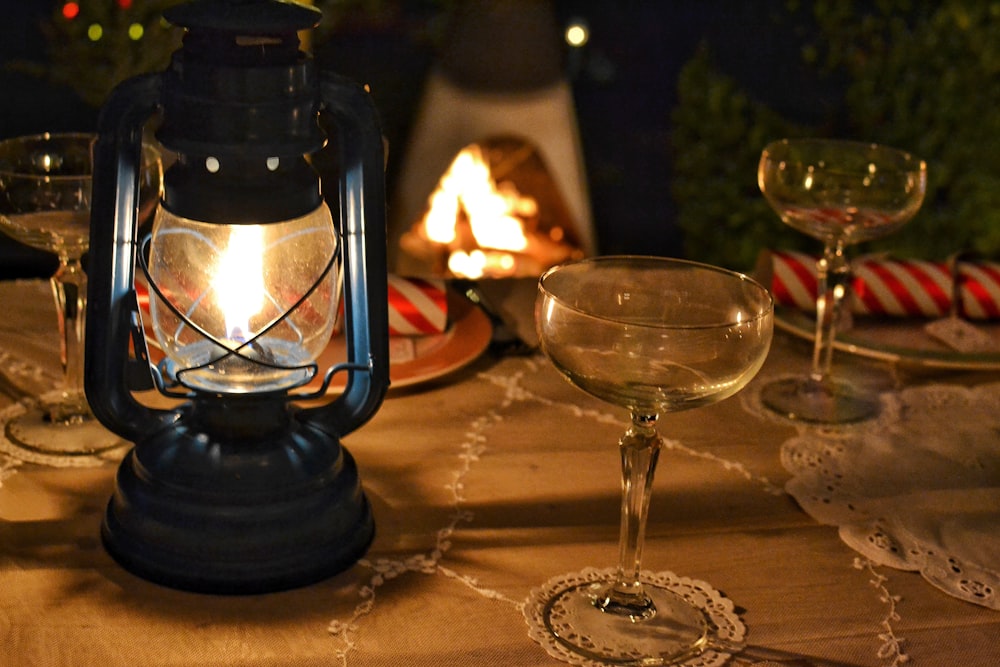 lighted tubular lantern beside empty cocktail glass