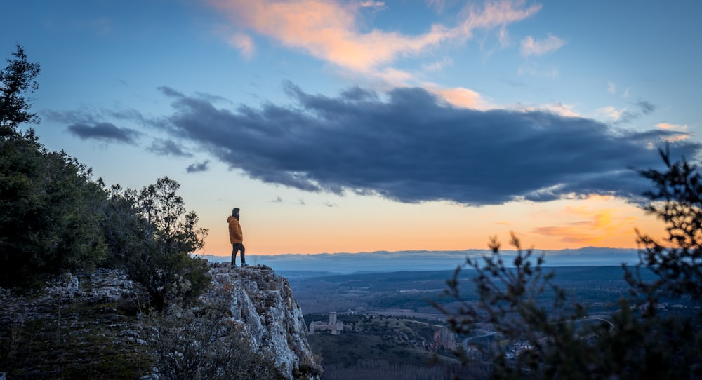 Persona de pie en la cima de una formación rocosa