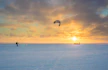 person parachute water skiing during golden hour