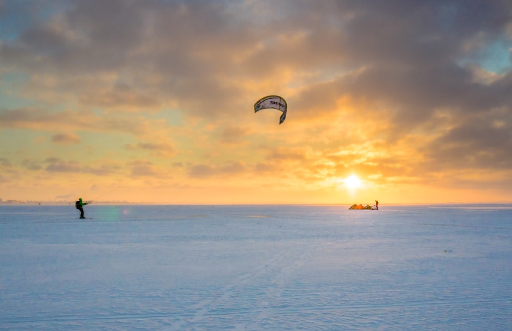 person parachute water skiing during golden hour