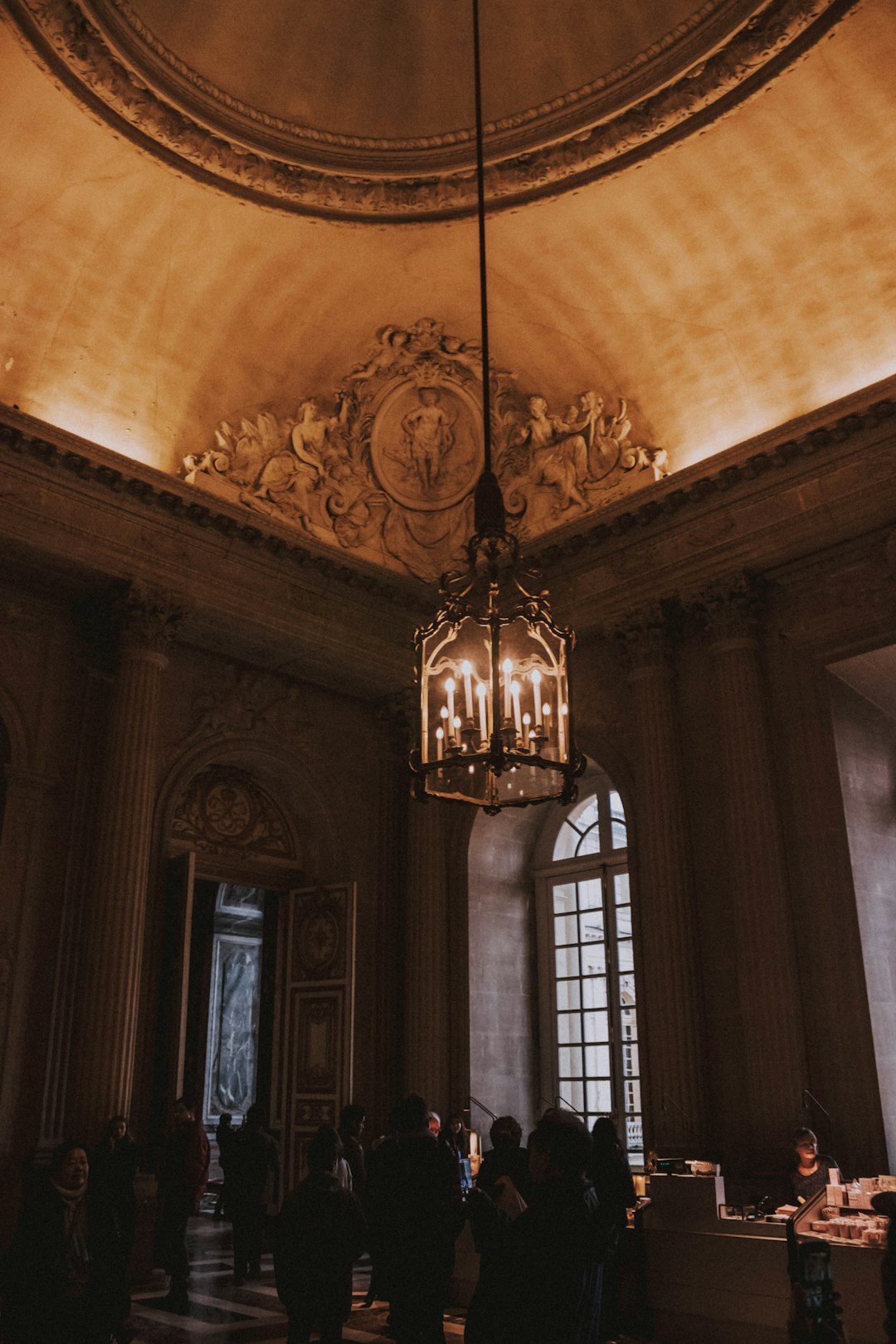 people gathering on brown painted room with turned-on chandelier