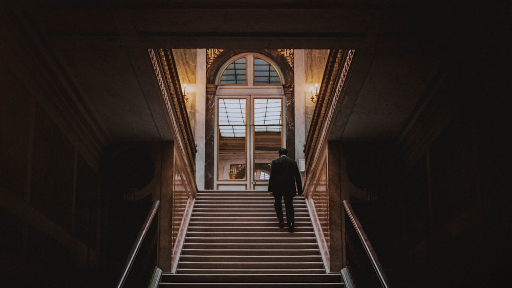 man climbing stairs heading arch mirror