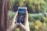 A happy traveler using a smartphone in a scenic outdoor location.