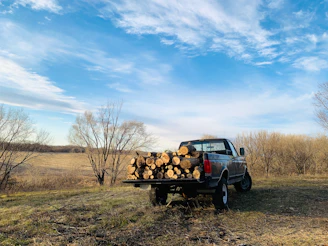 Delivery truck loaded with timber planks leaving the Eldoret timber yard on a clear day.