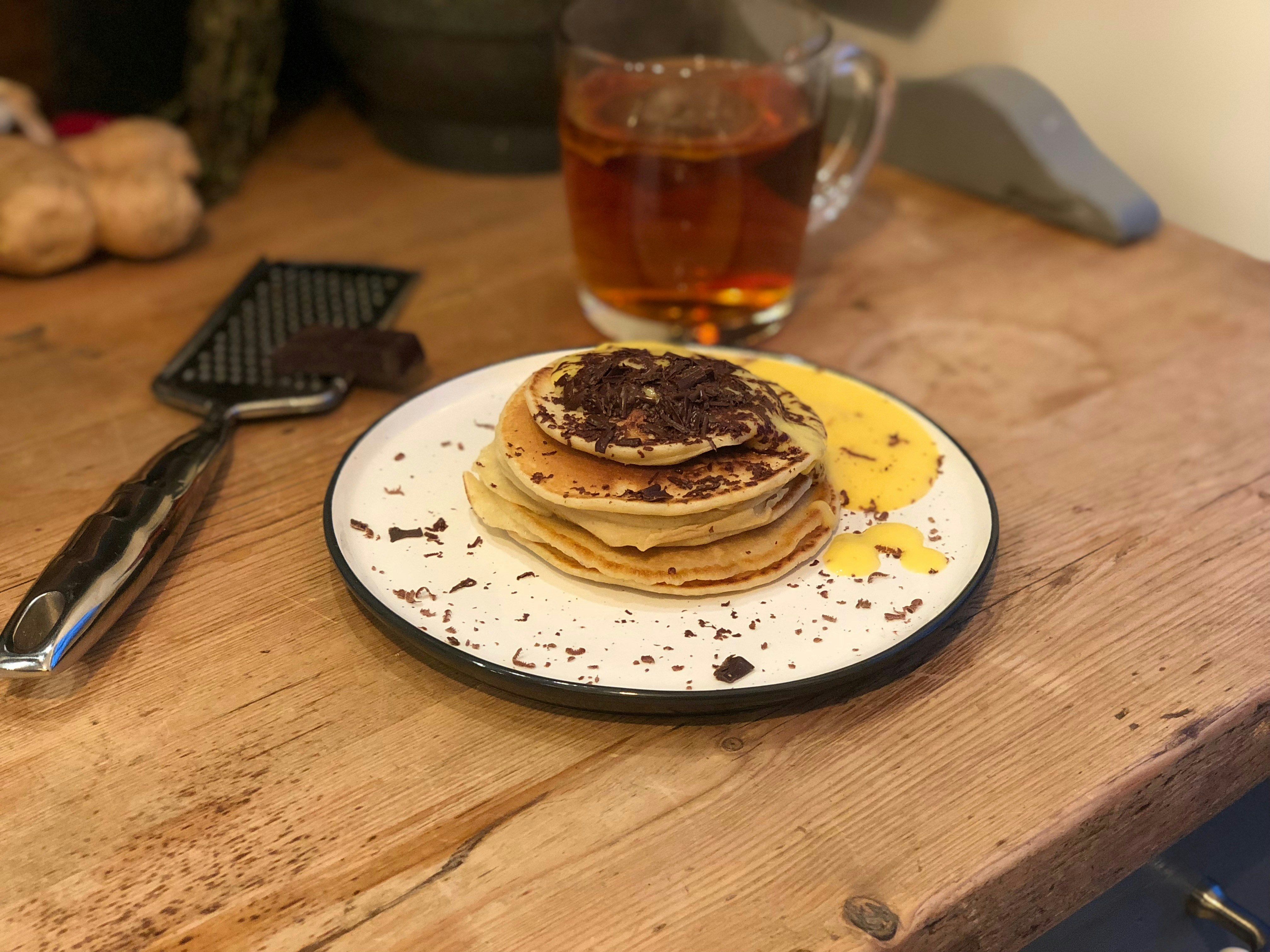 Pancakes with tea on a wooden table