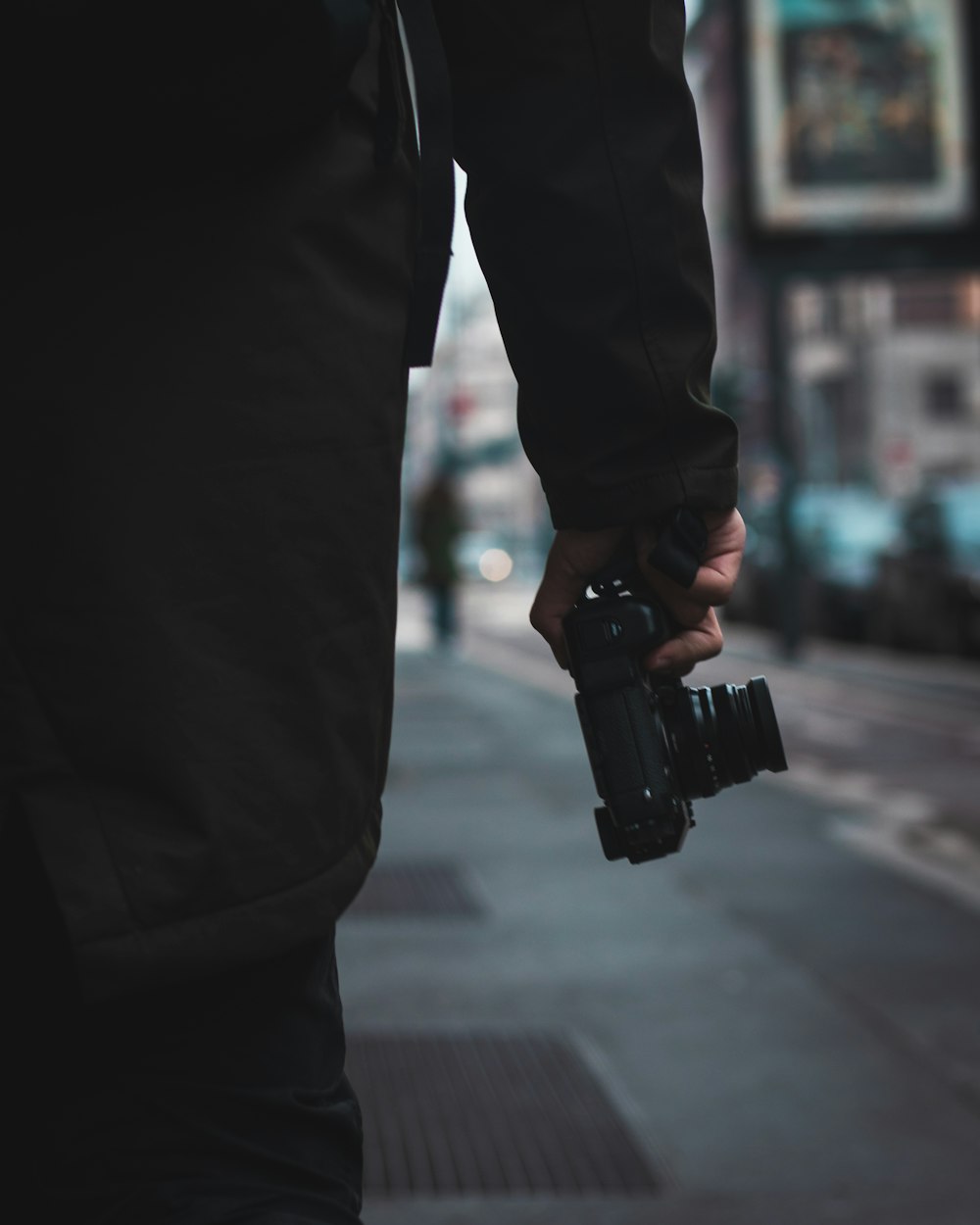 person holding camera walking in road