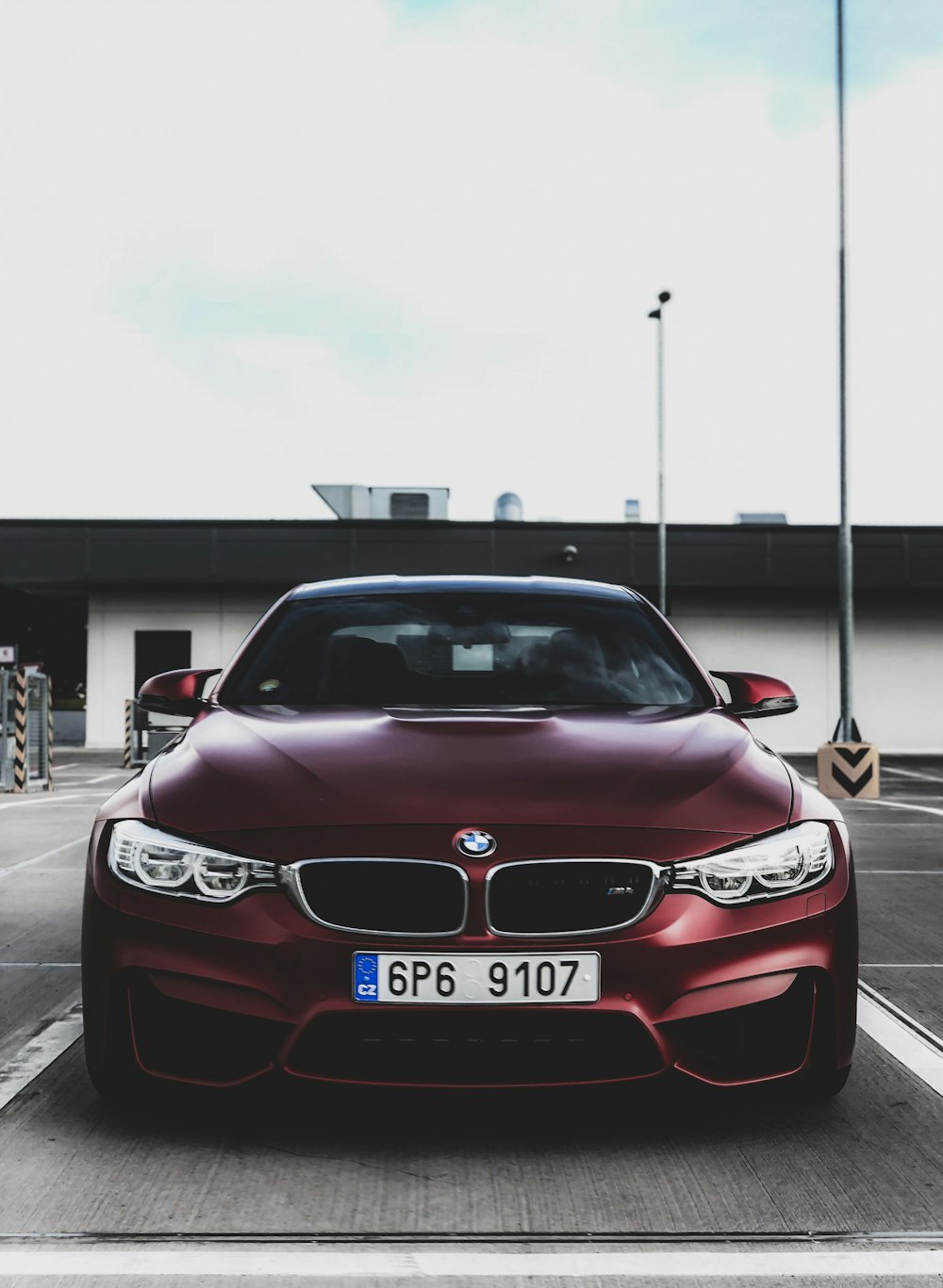 red BMW car parked near building