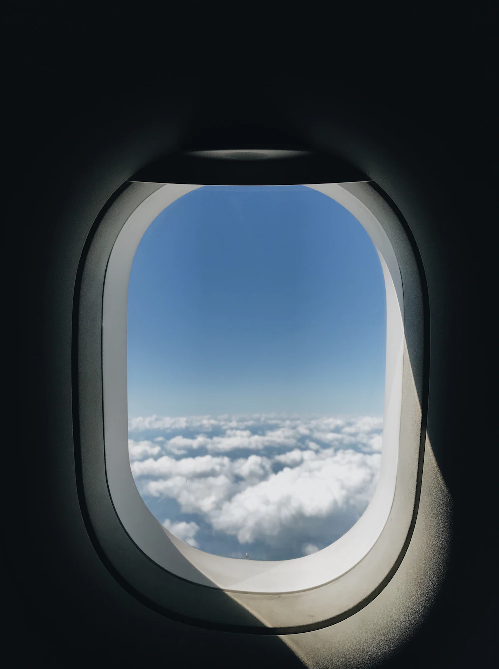 Aircraft window above the clouds