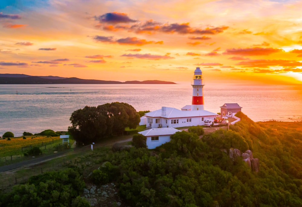 white concrete house beside lighthouse