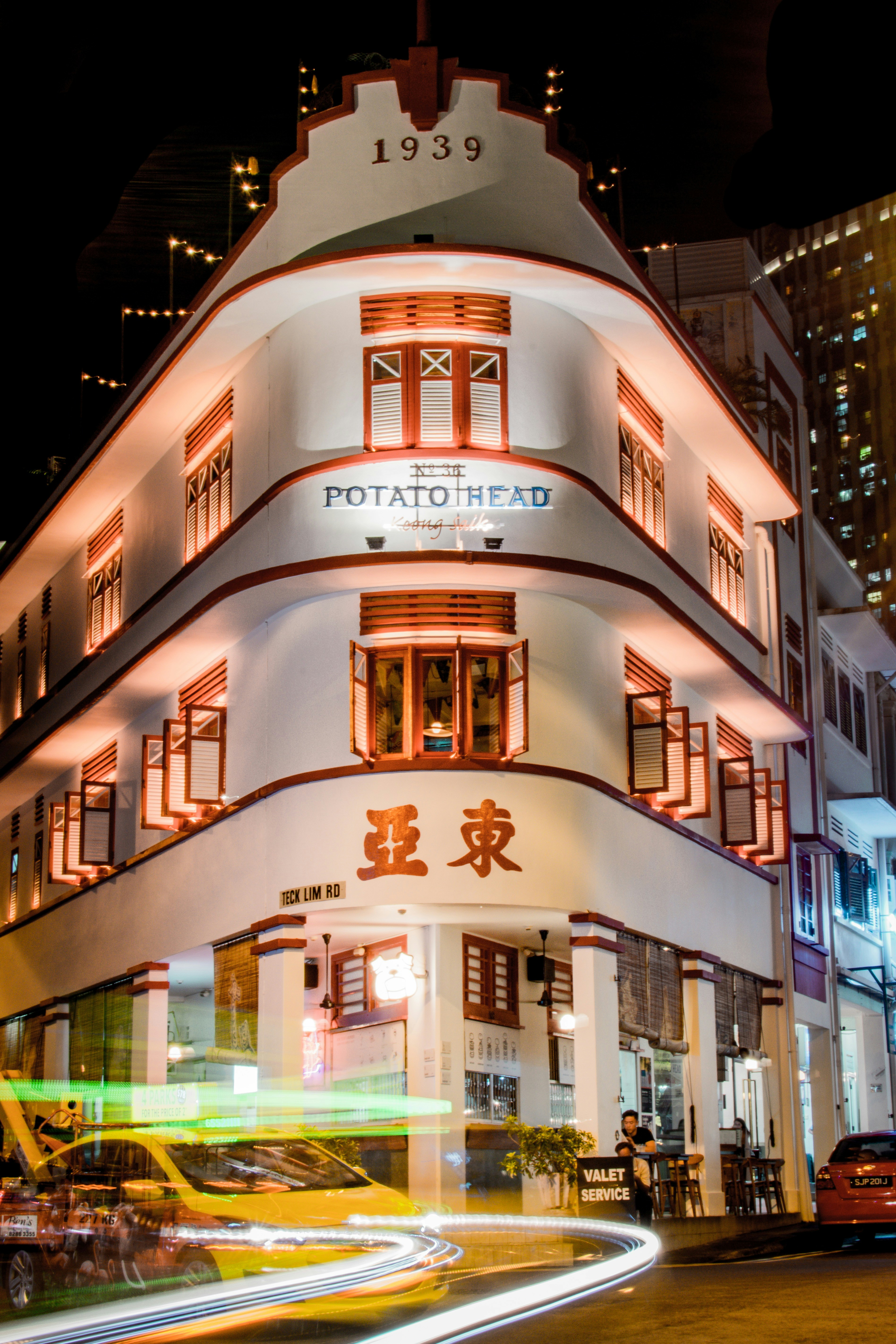 lighted white Potato Head building at night