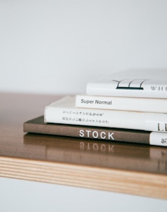 A stack of beautifully designed books on a wooden table.