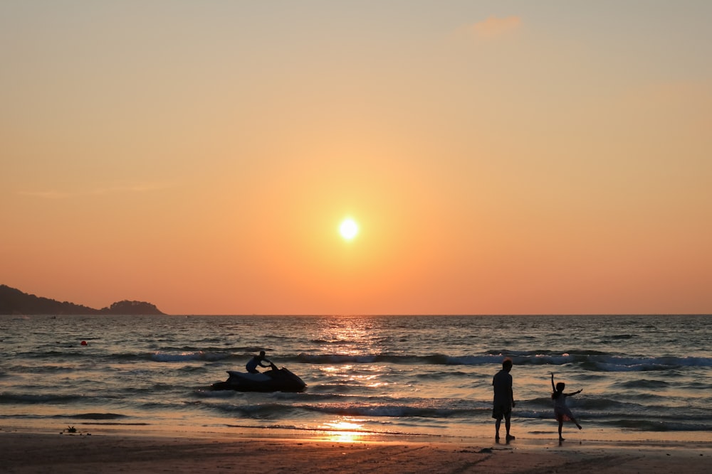 silhouette photography of two person standing at beach