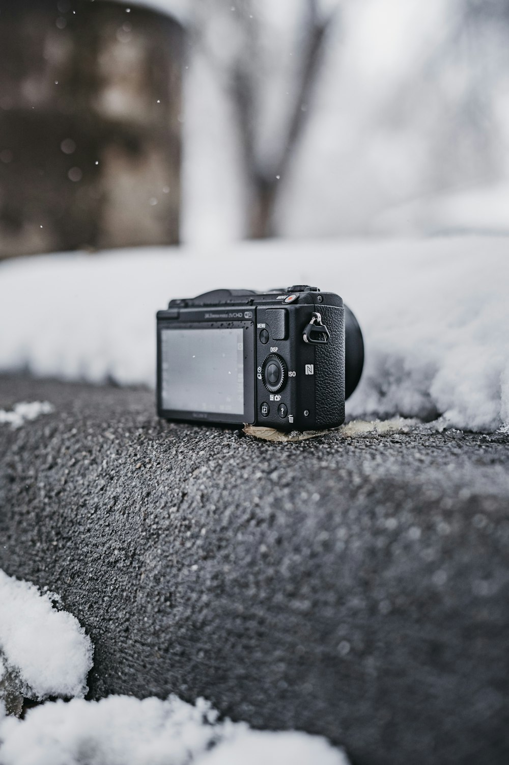 black point-and-shoot camera on gray surface outdoor